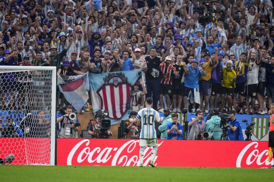 Argentina's Lionel Messi stands in front of fans in the stands.