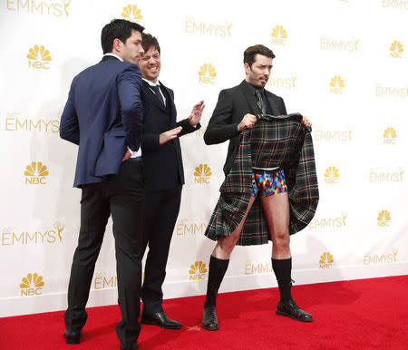 Jonathan Scott (R) of the reality series "Property Brothers" shows off his colorful underwear under his kilt as brother Drew Scott (L) and brother J.D. Scott look on. REUTERS/Lucy Nicholson