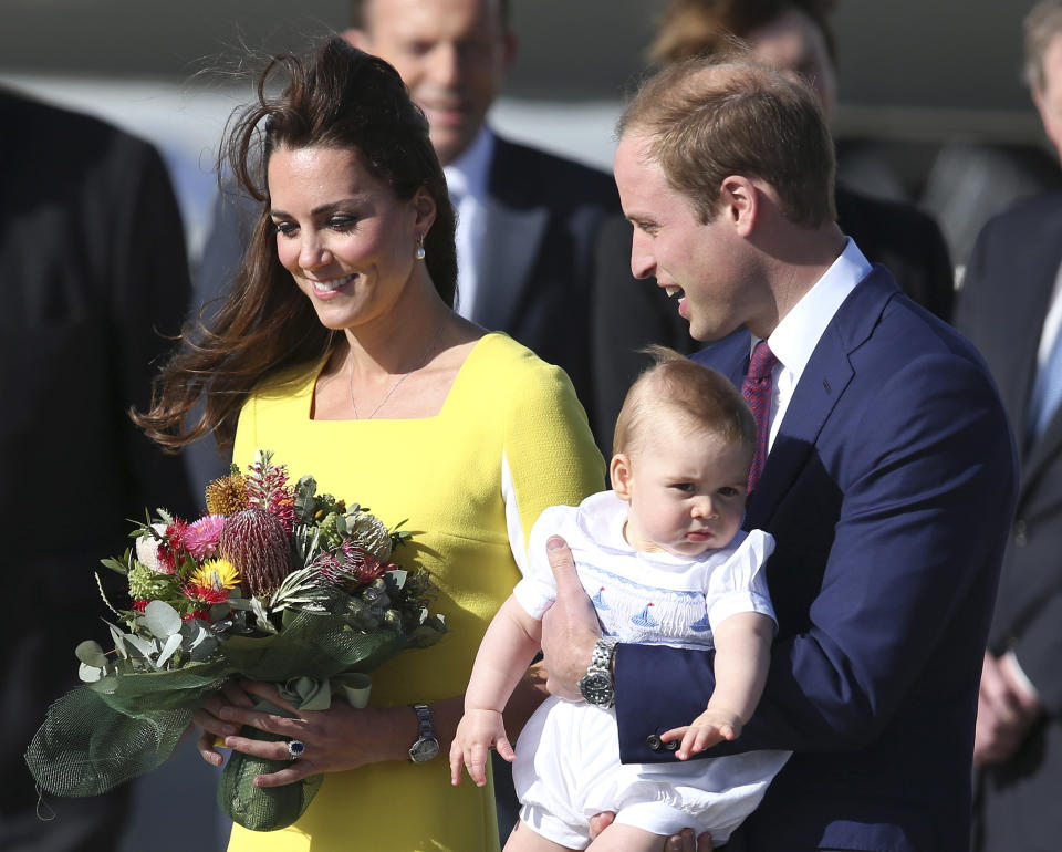 Britain's Prince William holding his son Prince George and his wife Kate, Duchess of Cambridge, arrive in Sydney Wednesday, April 16, 2014. The royal couple are on a three-week tour of Australia and New Zealand, the first official trip overseas with their son, Prince George. (AP Photo/Rob Griffith)