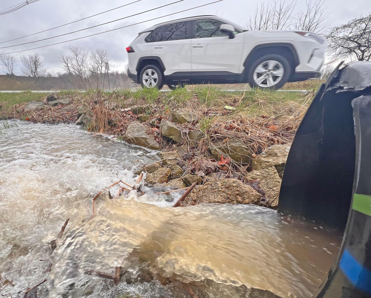 A driver speeds by a flowing temporary stream in Richland County earlier this spring.