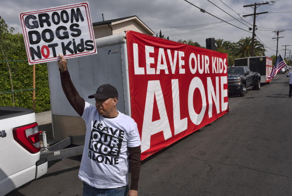 A protestor holds a sign in front of the Saticoy Elementary School in the North Hollywood section of Los Angeles on Friday, June 2, 2023. Police officers separated groups of protesters and counter-protesters outside the Los Angeles elementary school that has become a flashpoint for Pride month events across California. (AP Photo/Richard Vogel)