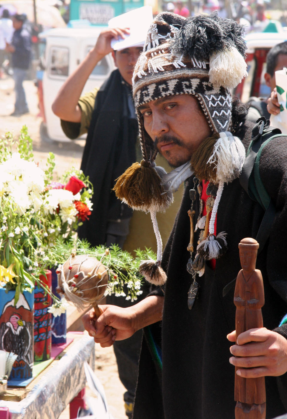 In this Nov. 1, 2012 photo, Shaman Paul Naveda calls the spirits with a maraca during the procession of Santa Muerte during the Day of the Dead festival at the Cemetery of Nueva Esperanza in Villa Maria del Triunfo in Lima, Peru. (AP Photo/Jody Kurash)