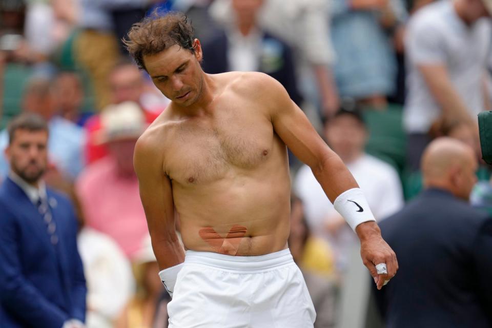 Rafael Nadal sported strapping on his stomach during a gruelling five-set win over Taylor Fritz (AP)