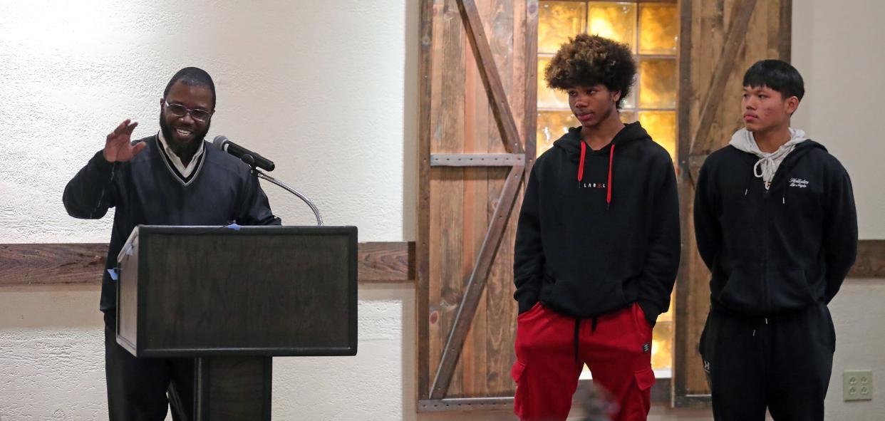 North boys basketball coach Devin Williams speaks as Rickey Boykins and Eh Ther Htoo look on during the Akron City Series high school basketball media day at Guy's Party Center on Tuesday in Akron.