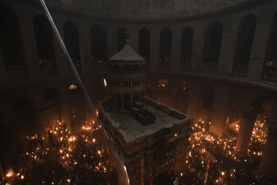 Christian pilgrims hold candles during the Holy Fire ceremony, a day before Easter, at the Church of the Holy Sepulcher, where many Christians believe Jesus was crucified, buried and resurrected, in Jerusalem's Old City, Saturday, April 15, 2023. (AP Photo/Mahmoud Illean)