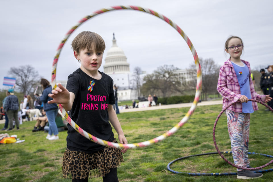 Mac Gordon Frith, 6, left, who is here supporting his sibling, Caleta Frith, 9, right, who is non-binary, uses a hula hoop during a rally on the Transgender Day of Visibility, Friday, March 31, 2023, by the Capitol in Washington. Transgender people and their allies gathered at venues across the country Friday as part of an annual, international recognition of transgender resilience, an observation that this year comes amid what some denounced as an increasingly hostile climate. (AP Photo/Jacquelyn Martin)