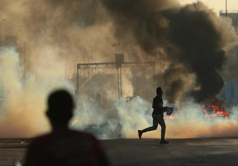 Anti-government protesters set fires and close a street during a demonstration in Baghdad, Iraq, Saturday, Oct. 5, 2019. Iraqi protesters pressed on with angry anti-government rallies across several provinces, in some cases torching party offices, for the fifth day, ignoring appeals for calm from political and religious leaders. Security agencies kept up their heavy crackdown, firing live ammunition and killing more than 14 protesters Saturday. (AP Photo/Hadi Mizban)