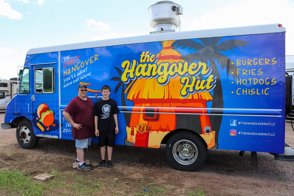 From left, Darin and Ryan Bennings (14) pose in front of their new food truck, The Hangover Hut, in Harrisburg on Thursday, June 2. The father-son duo made their debut in the Sioux Falls area last week.