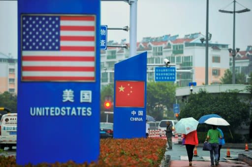 Signs with the US and Chinese flags hang outside a store selling foreign goods in Qingdao, eastern Shandong province, a day after Beijing announced an additional $60 billion in retaliatory tariffs on US goods