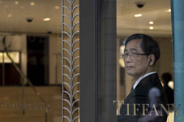 A security guard is seen standing by the entrance of a luxury jewellery store in Hong Kong, on August 7, 2014