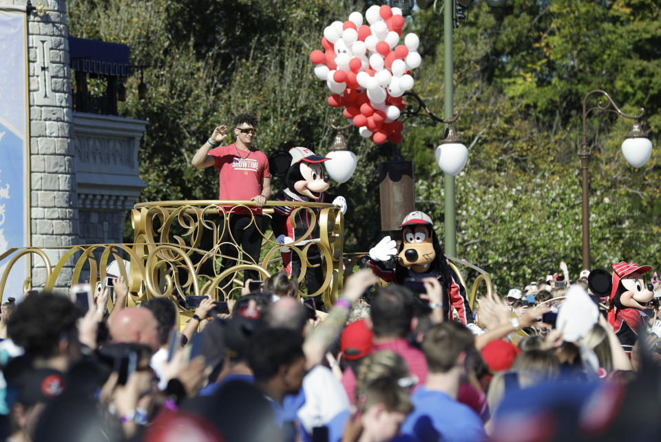 Super Bowl MVP Kansas City Chiefs quarterback Patrick Mahomes stands next to Mickey Mouse and waves to fans during a parade at the Magic Kingdom theme park at Walt Disney World, Monday, Feb. 3, 2020, in Lake Buena Vista, Fla. (AP Photo/John Raoux)