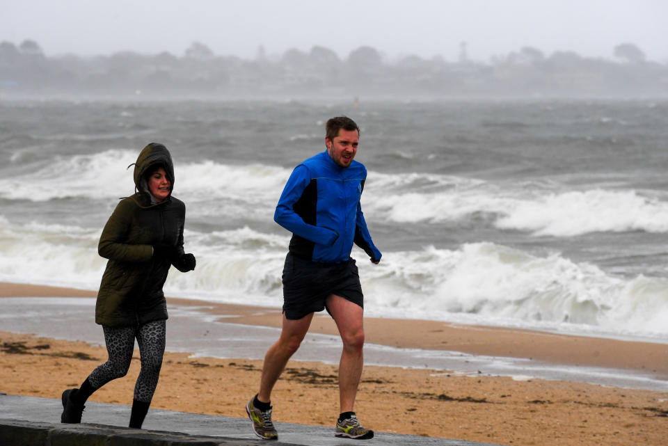 Joggers are seen at Elwood Beach, Melbourne in August 2018. Temperatures in Victoria will be below average to start winter. Source: AAP