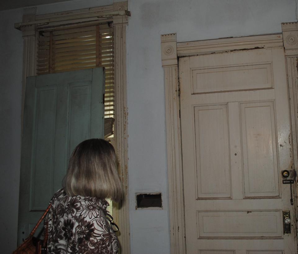 Owner Marcia McCoy points out some unique crown molding that remains around a doorway and window in her family's old Victorian home at 1400 Travis St.