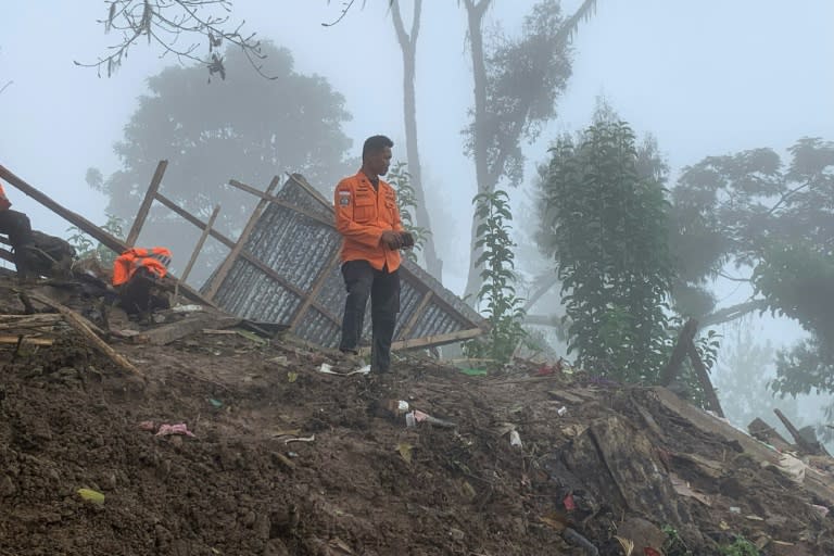 Un miembro de un equipo de rescate busca a personas desaparecidas en el corrimiento de tierras que dejó al menos 18 muertos y dos desaparecidos en Tana Toraja, el 15 de abril de 2024 en el centro de Indonesia (.)