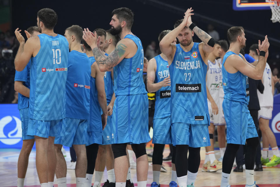 Slovenia guard Luka Doncic (77) and teammates clap after winning against Italy during the Basketball World Cup classification match in Manila, Philippines, Saturday, Sept. 9, 2023. (AP Photo/Aaron Favila)