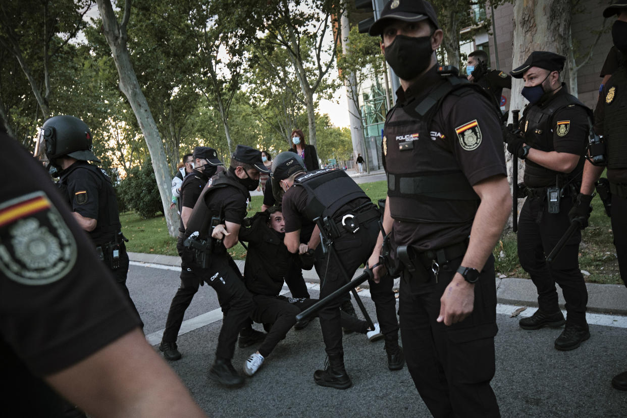 La policía detiene a un manifestante durante una protesta el 24 de septiembre de 2020, en contra de las restricciones del coronavirus en Puente de Vallecas, uno de los barrios de Madrid bajo cierre parcial. (Gianfranco Tripodo/The New York Times)