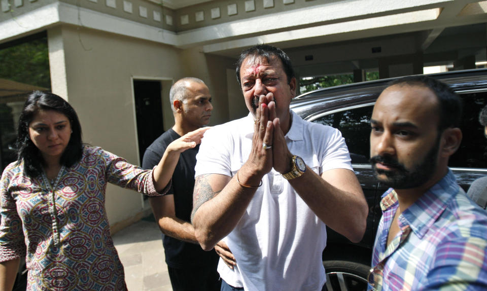 Indian Bollywood actor Sanjay Dutt, center, gestures to the media after he broke down during a press conference as his sister Priya Dutt, left, stands next to him at his residence in Mumbai, India, Thursday, March 28, 2013. Dutt said he has not sought pardon for a 1993 weapons conviction and will serve his prison sentence as ordered by India's Supreme Court. Dutt broke his silence a week after the court sentenced him to five years in prison for illegal possession of weapons supplied by Mumbai crime bosses linked to a 1993 terror attack that killed 257 people.(AP Photo/Rafiq Maqbool)