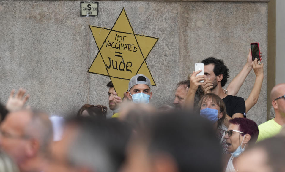 FILE - In this Saturday, July 24, 2021 file photo, people stage a protest against the "green pass" in Milan, Italy. Protesters in Italy and in France have been wearing yellow Stars of David, like the ones Nazis required Jews to wear to identify themselves during the Holocaust. Some carry signs likening vaccine passes to dictatorships. (AP Photo/Antonio Calanni, File)
