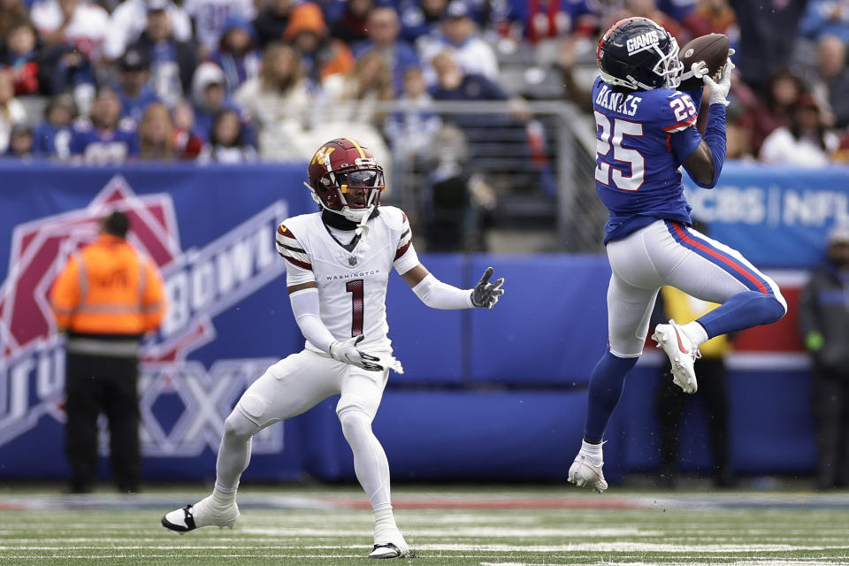 New York Giants cornerback Deonte Banks (25) intercepts a pass intended for Washington Commanders wide receiver Jahan Dotson (1) during the second quarter of an NFL football game, Sunday, Oct. 22, 2023, in East Rutherford, N.J. (AP Photo/Adam Hunger)