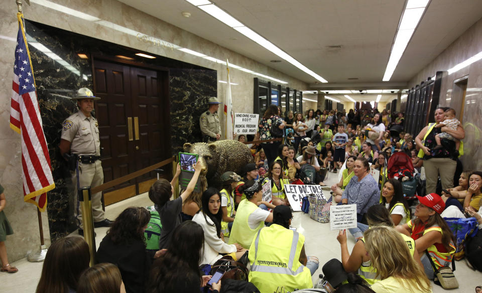 Opponents of a measure that would give public health officials oversight of doctors that may be giving fraudulent medical exemptions from vaccinations during gathered in front of the governor's office after it was approved by the Assembly Health Committee at the Capitol in Sacramento, Calif., Thursday, June 20, 2019.(AP Photo/Rich Pedroncelli)