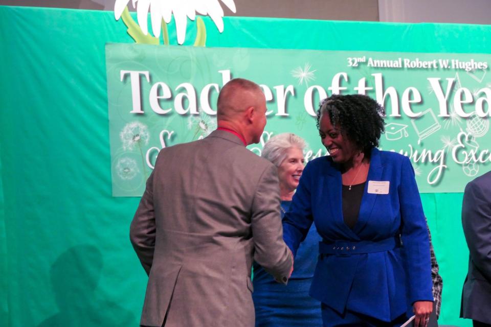 Dwynette Smith, Alachua County's 2024 Teacher of the Year, shakes hands with Superintendent Shane Andrew.