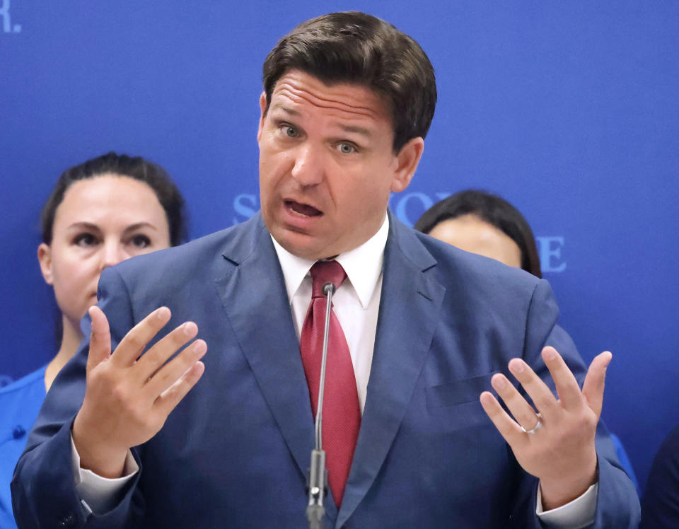 Gov. Ron DeSantis makes his point emphatically in front of a microphone.