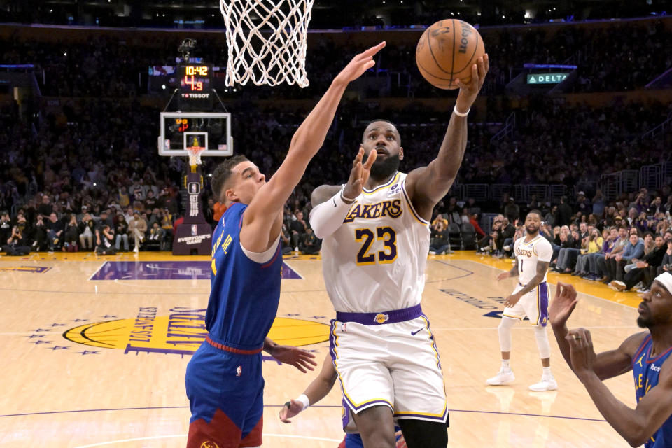 Mar 2, 2024; Los Angeles, California, USA; Los Angeles Lakers forward LeBron James drives past Denver Nuggets forward Michael Porter Jr. to score his 40,000th career point at Crypto.com Arena. Credit: Jayne Kamin-Oncea-USA TODAY Sports