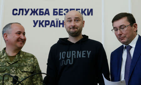 Russian journalist Arkady Babchenko (C), who was reported murdered in the Ukrainian capital on May 29, Ukrainian Prosecutor General Yuriy Lutsenko (R) and head of the state security service (SBU) Vasily Gritsak attend a news briefing in Kiev, Ukraine May 30, 2018. REUTERS/Valentyn Ogirenko