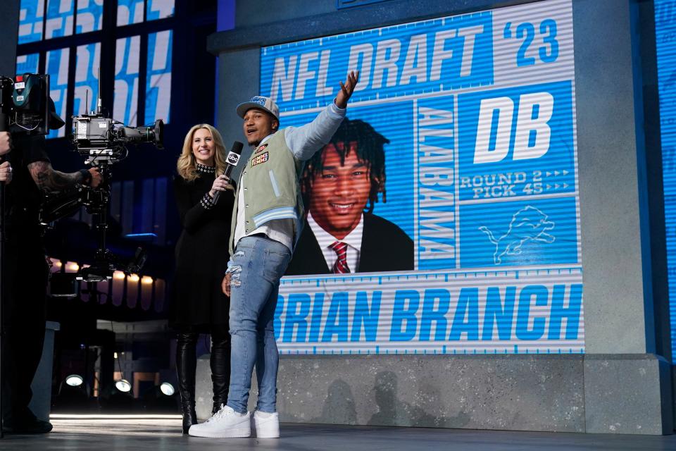 Alabama defensive back Brian Branch, right, reacts after being chosen by the Detroit Lions during the second round of the NFL draft, Friday, April 28, 2023, in Kansas City, Mo.