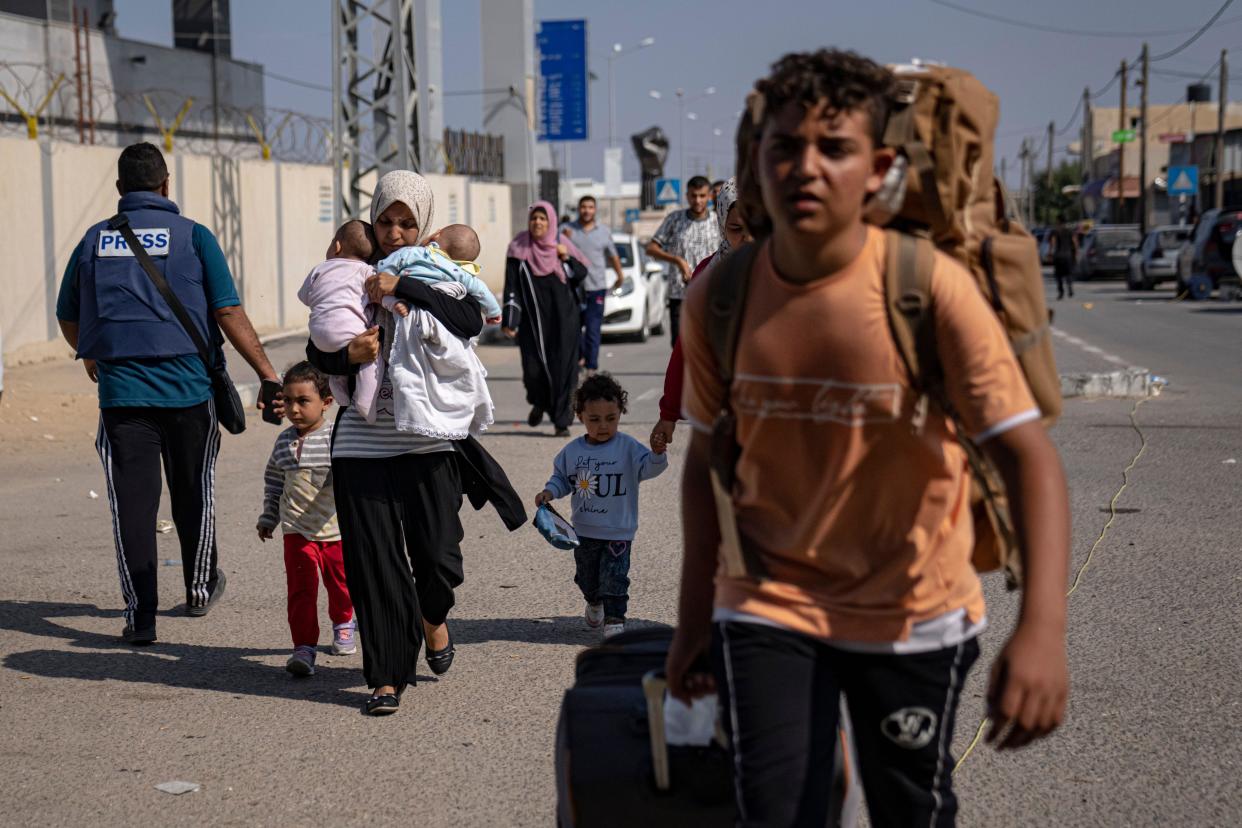 Palestinians arrive at Rafah, the border crossing between the Gaza Strip and Egypt, on Wednesday, Nov. 1, 2023. (AP Photo/Fatima Shbair)