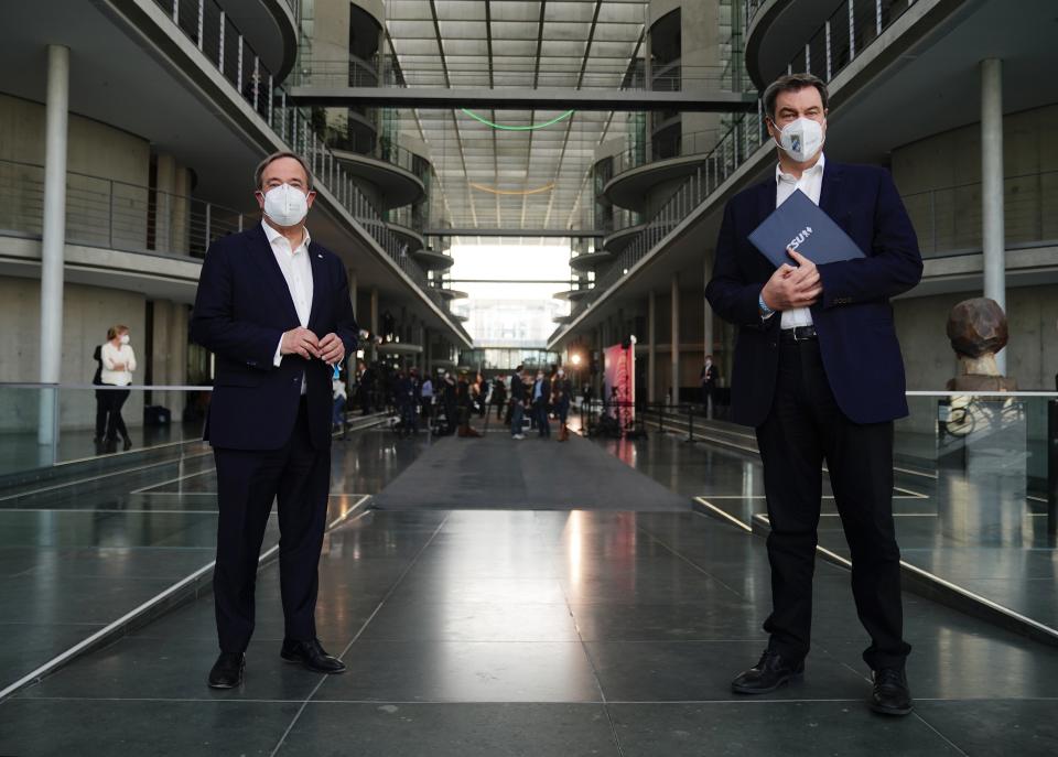 The chairman of the German Christian Democratic Party (CDU), ArminLaschet, left, and the chairman of the German Christian Social Union (CSU), Markus Soeder, right, after a statement folowing a closed meeting of the federal parliament factions of both partys in Berlin, Germany, Sunday, April 11, 2021. The two party chairmen and German state governors want to become the center-right candidate for the country's Sept. 26 national election, the German news agency dpa reported Sunday. (Michael Kappeler/dpa via AP)