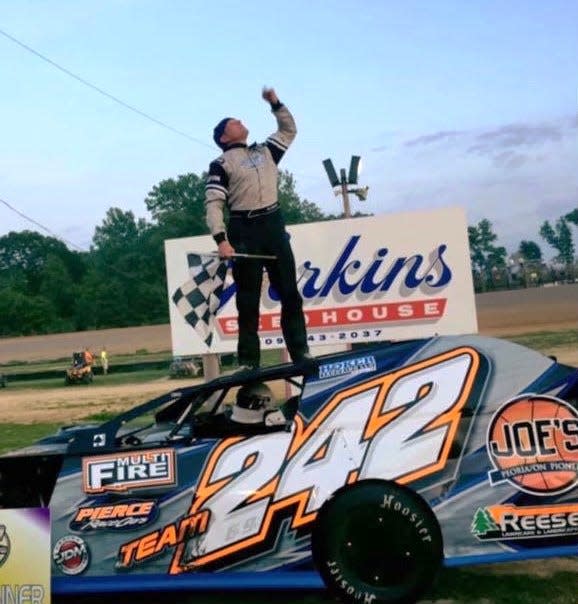 Brad Willis Jr. celebrates a race victory at Spoon River Speedway in 2017, two weeks after his father, Brad Sr., died. He pays tribute, looking skyward and pointing up.