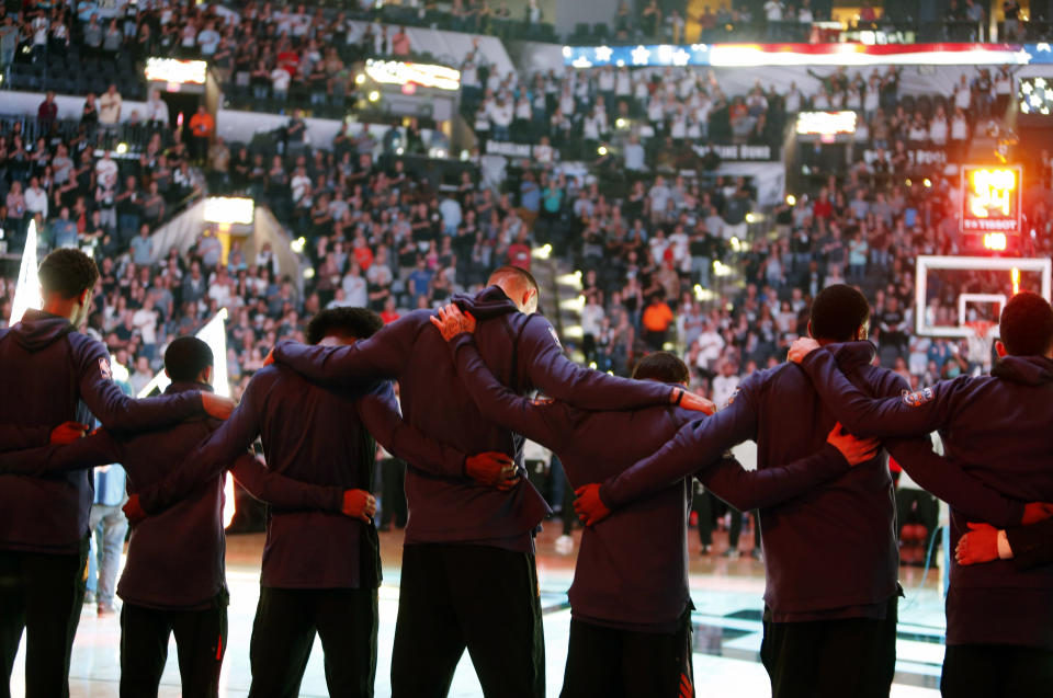 <p>Members of the Phoenix Suns stand arm-in-arm during a moment of silence for the victims of a deadly church shooting in Texas before an NBA basketball team against the San Antonio Spurs, Sunday, Nov. 5, 2017 in San Antonio. (Photo: Ronald Cortes/AP) </p>