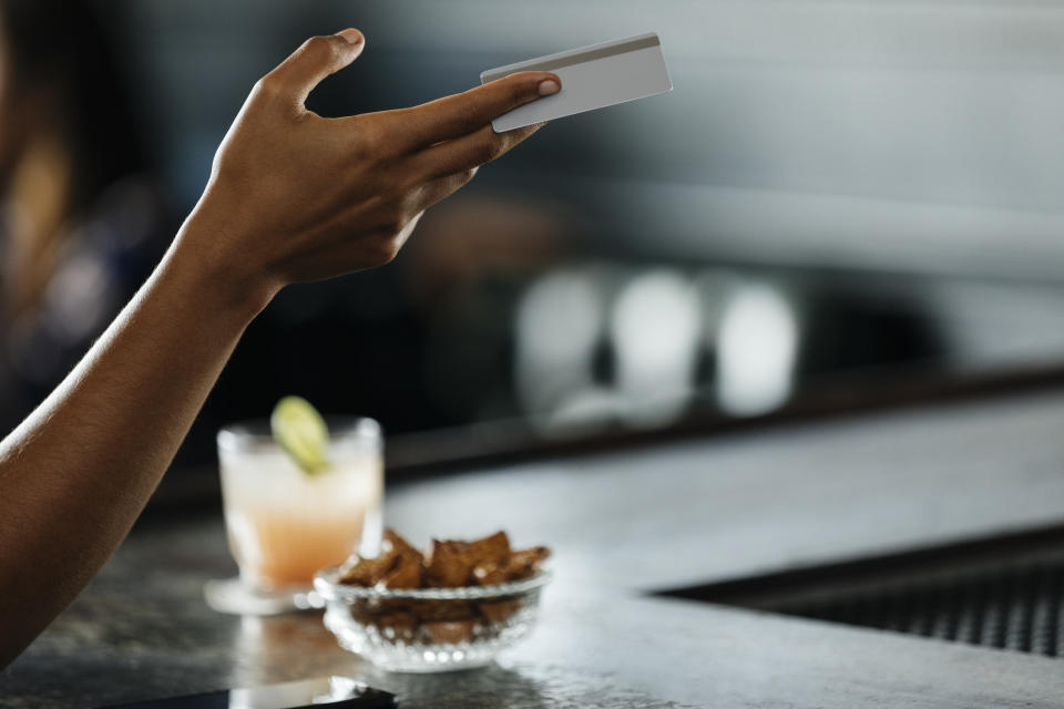 A woman holding a credit card.