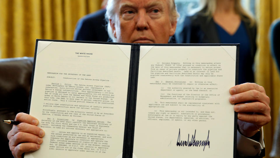 President Donald Trump holds up a signed executive order to advance construction of the Dakota Access pipeline at the White House on Jan. 24, 2017. (Photo: Kevin Lamarque/Reuters)