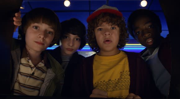 Stranger Things 2 characters Will, Mike, Dustin, and Lucas looking into the camera.