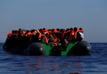 Migrants on a rubber dinghy await rescue by the Malta-based NGO Migrant Offshore Aid Station (MOAS) in the central Mediterranean in international waters some 15 nautical miles off the coast of Zawiya in Libya, April 14, 2017. REUTERS/Darrin Zammit Lupi