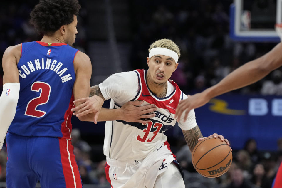 Washington Wizards forward Kyle Kuzma (33) drives as Detroit Pistons guard Cade Cunningham (2) defends during the first half of an NBA basketball game, Monday, Nov. 27, 2023, in Detroit. (AP Photo/Carlos Osorio)