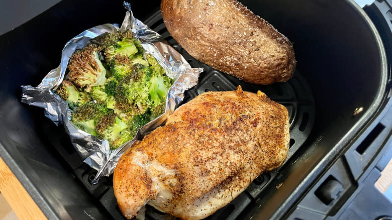 Cooking chicken and broccoli in an air fryer with a potato