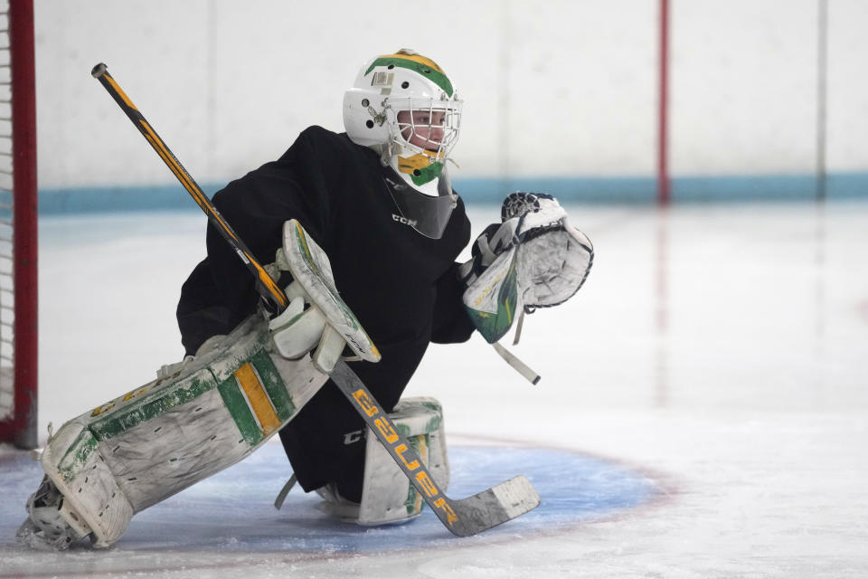 Evan Smolik defends the goal during hockey practice Wednesday, Nov. 29, 2023, in Edina, Minn. When Evan was 14, a teammate's skate struck his neck and his jugular vein, but the neck guard he was wearing prevented the skate from cutting his carotid artery and helped save his life. (AP Photo/Abbie Parr)