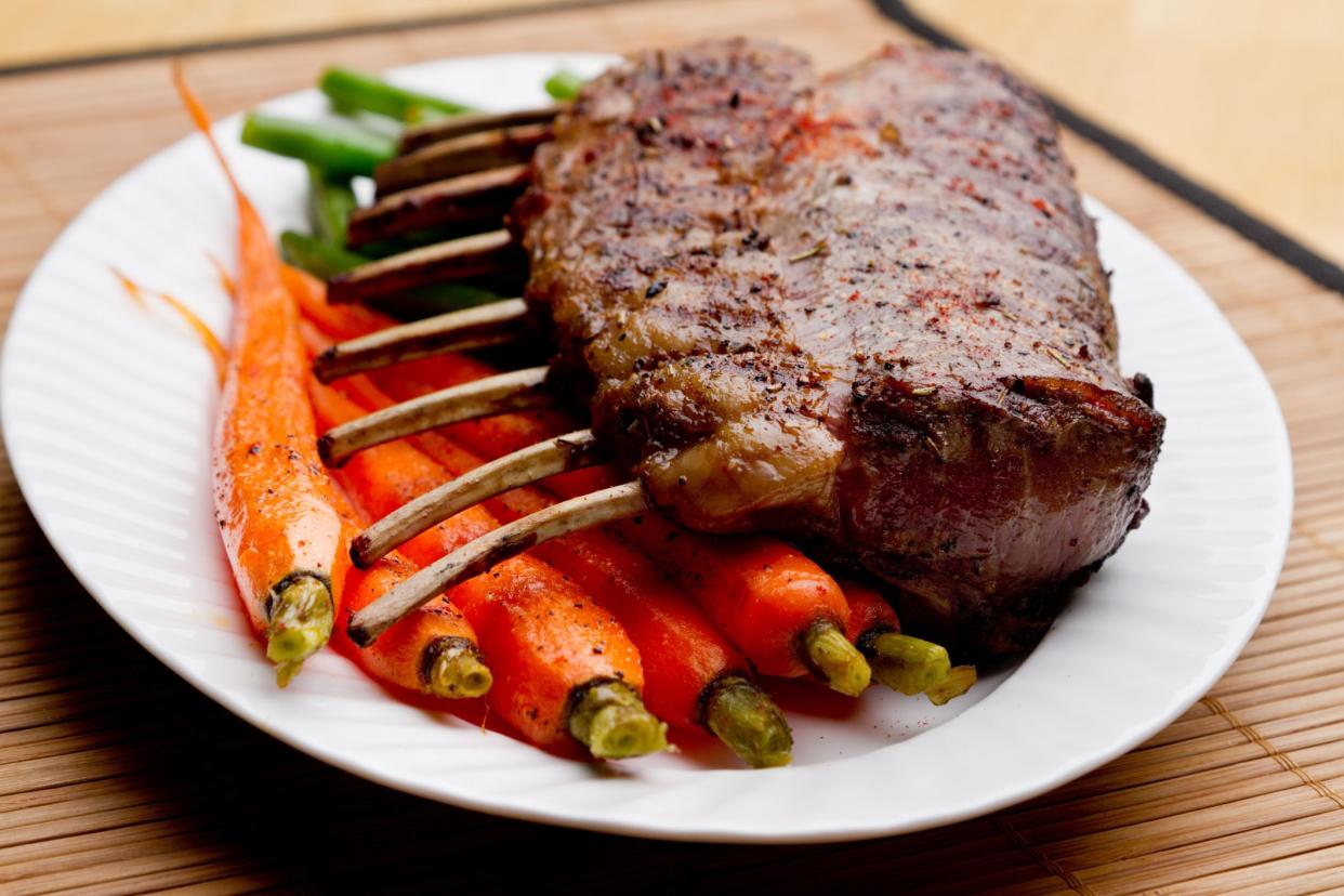 Rack of Lamb with Carrots and Green Beans on a white plate