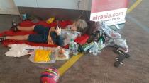 Stranded tourists sit in chairs at the transit area of Kuala Lumpur International Airport in Sepang