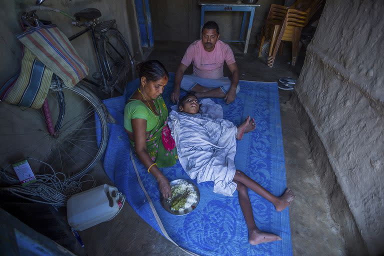 Shambhu Chaudhary sy su mujer, Deukali Devi, con su hijas Sajan., en Bhokteni, Nepal