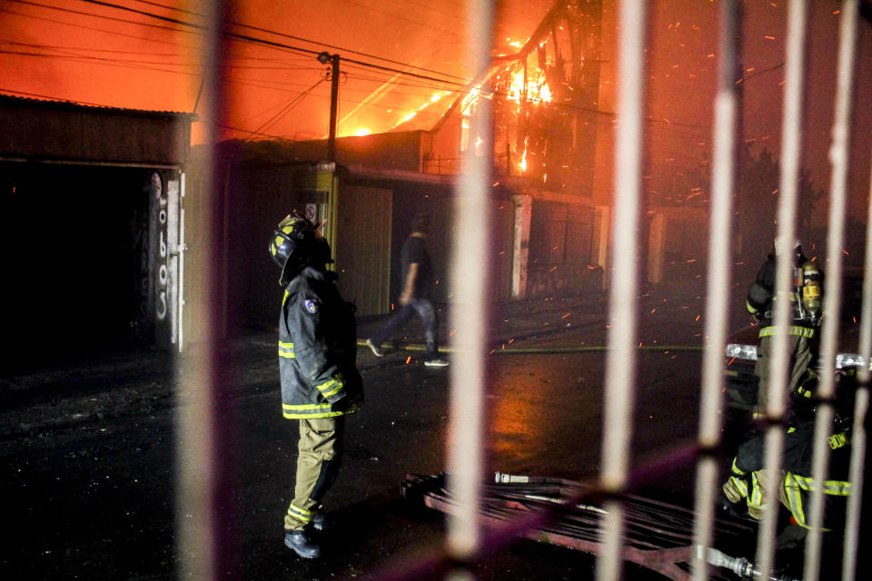 Un bombero mira al cielo mientras un incendio forestal arrasa edificios en Viña del Mar, Chile, el 2 de febrero de 2024. (AP Foto/Cristobal Basaure)