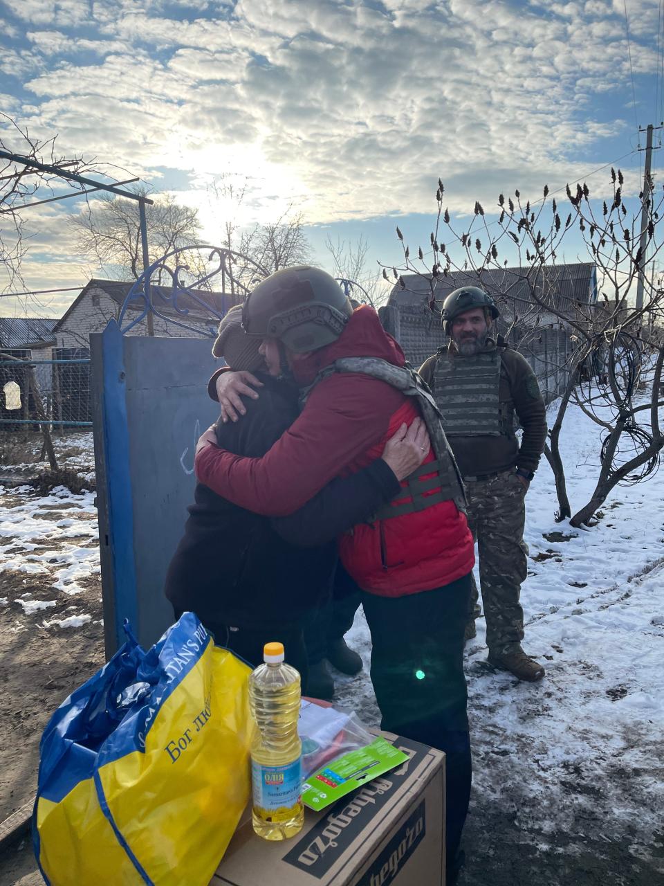 Lupaniek watches Taslim hug a Ukrainian resident.