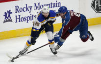 St. Louis Blues center Jordan Kyrou, left, looks to pass the puck as Colorado Avalanche defenseman Cale Makar reaches for it during the first period of an NHL hockey game Wednesday, Jan. 13, 2021, in Denver. (AP Photo/David Zalubowski)