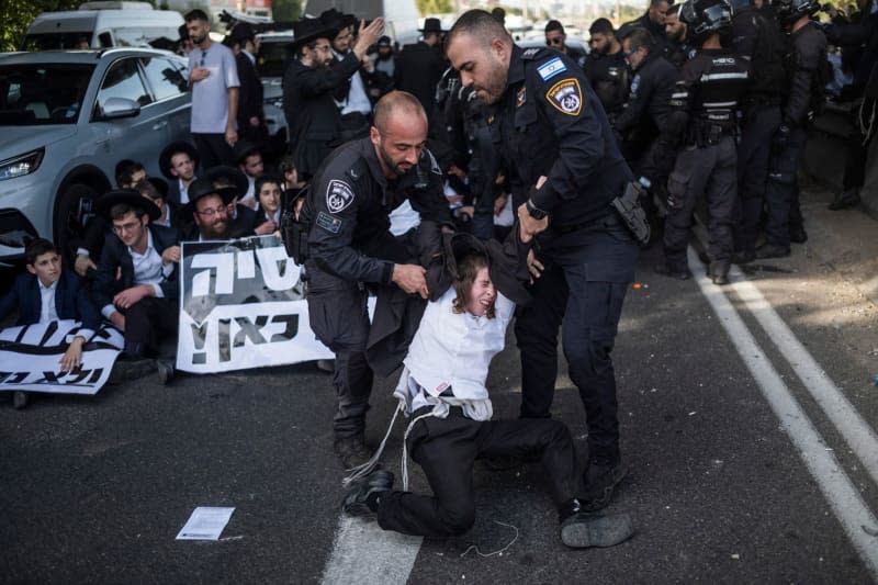 Ultra-Orthodox protesters block the road as they protest against the military draft bill. Ilia Yefimovich/dpa