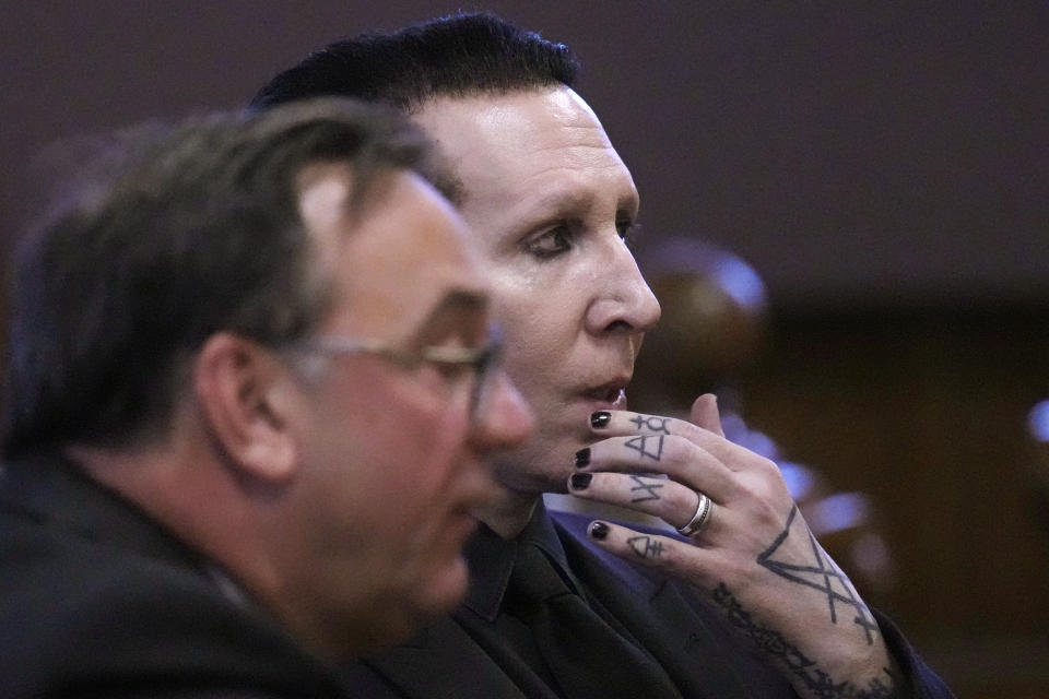 Musical artist Marilyn Manson, whose legal name is Brian Hugh Warner, right, sits with his attorney Kent Barker during an appearance in Belknap Superior Court,Monday, Sept. 18, 2023, in Laconia, N.H. Manson, who was charged with charged with two misdemeanor counts of simple assault, was accused of approaching a videographer at his 2019 concert in New Hampshire and allegedly spitting and blowing his nose on her. (AP Photo/Charles Krupa)