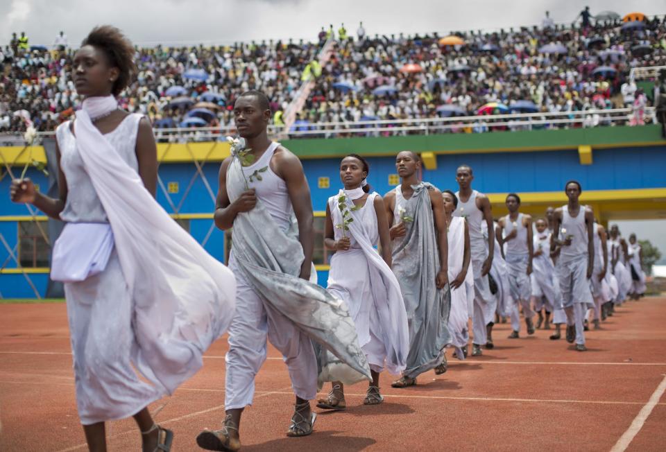 Performers re-enacting some of the events enter a public ceremony to mark the 20th anniversary of the Rwandan genocide, at Amahoro stadium in Kigali, Rwanda Monday, April 7, 2014. Sorrowful wails and uncontrollable sobs resounded Monday as thousands of Rwandans packed the country's main sports stadium to mark the 20th anniversary of the beginning of a devastating 100-day genocide. (AP Photo/Ben Curtis)