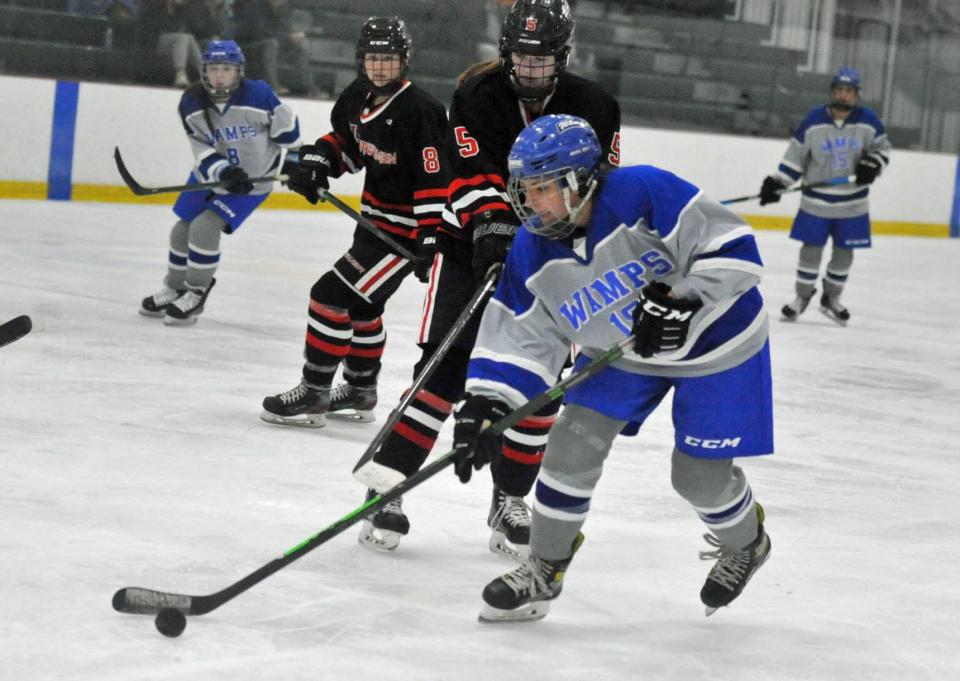 Braintree's Kelsie Littlewood, right, lines up a shot on goal as Hingham defenders Reese Pompeo, left, and Brenna Doherty, center, move in during the Tenney Cup Hockey Tournament at The Bog in Kingston, Monday, Dec. 26, 2022.